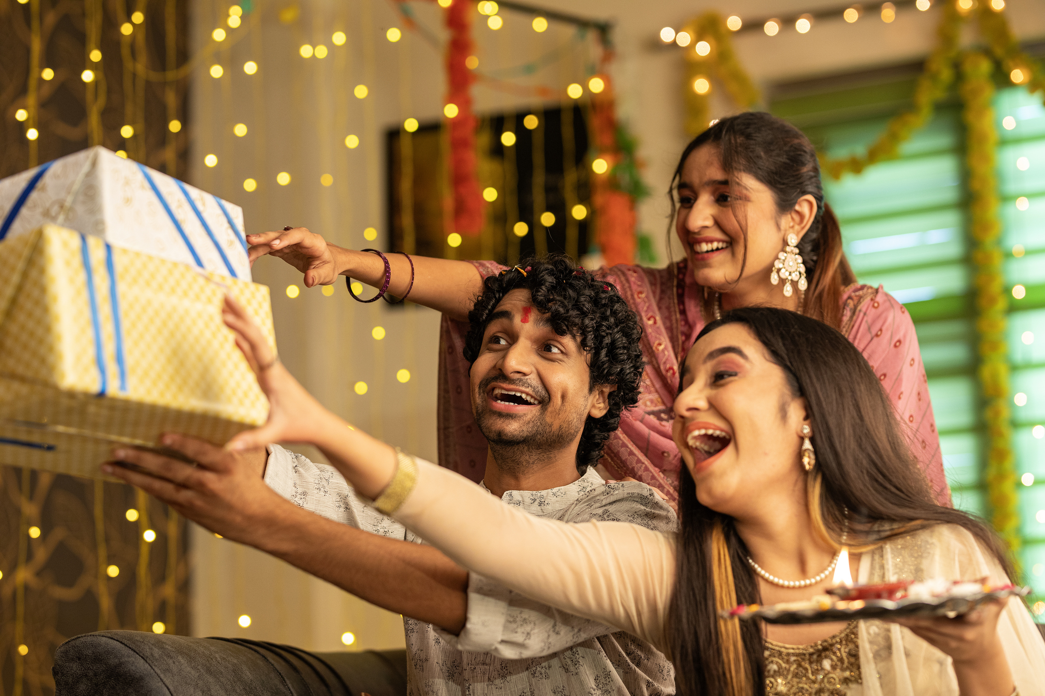 Cheerful siblings with gift boxes celebrating Raksha Bandhan festival